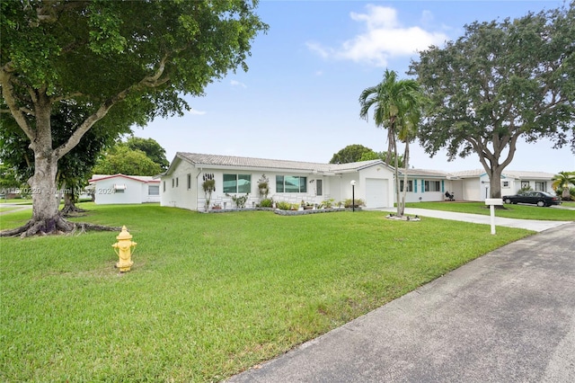 ranch-style home featuring a garage and a front lawn