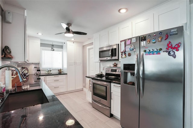 kitchen with stainless steel appliances, ceiling fan, sink, and white cabinetry