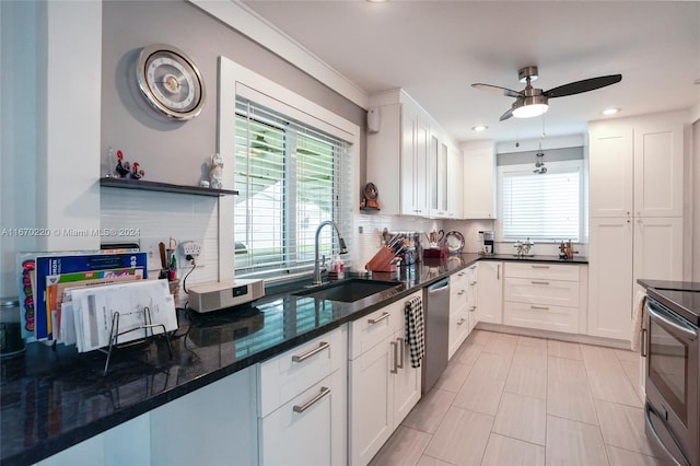 kitchen with stainless steel appliances, white cabinets, tasteful backsplash, and sink