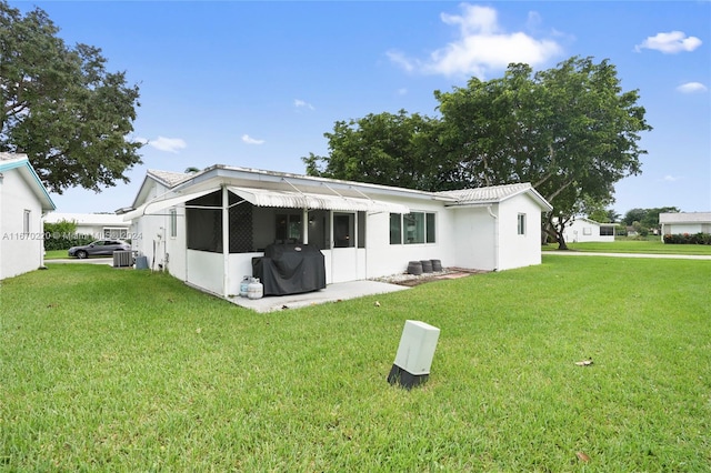 rear view of house with a sunroom and a lawn