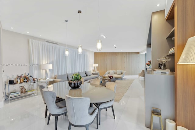 dining room with wood walls, light tile patterned floors, and recessed lighting