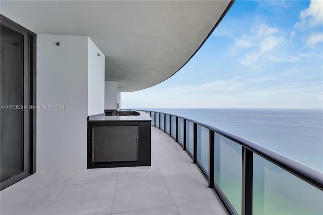 balcony featuring sink and a water view