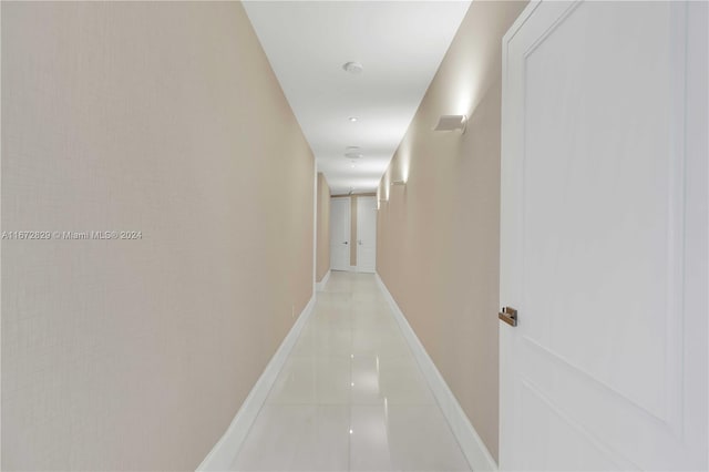 hall with light tile patterned floors and baseboards