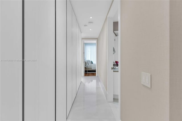hall with baseboards and recessed lighting