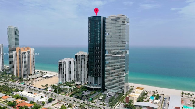 birds eye view of property featuring a beach view and a water view