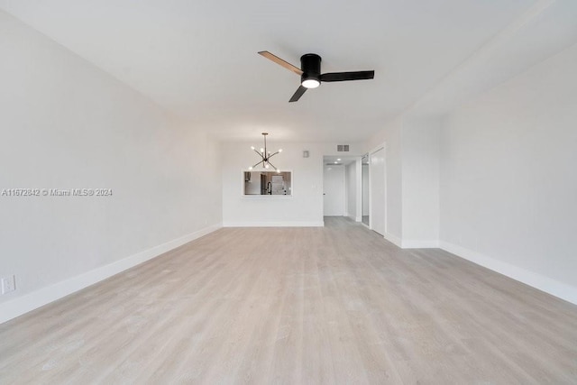 unfurnished living room featuring light wood-type flooring and ceiling fan with notable chandelier