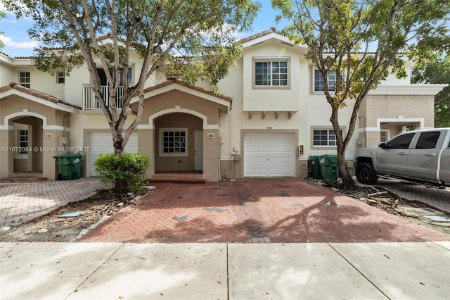 multi unit property featuring a balcony and a garage