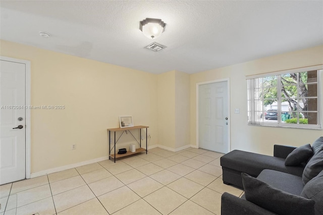 tiled living room featuring a textured ceiling