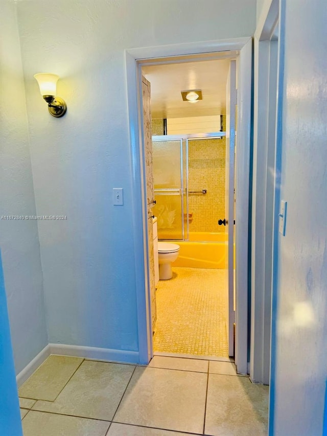 hallway featuring baseboards and light tile patterned floors