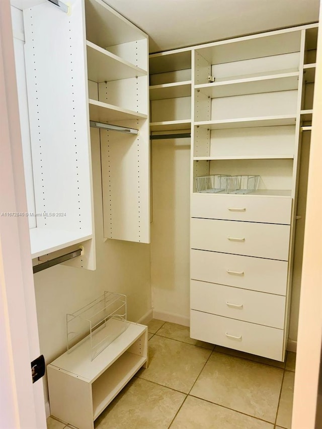 spacious closet with light tile patterned floors