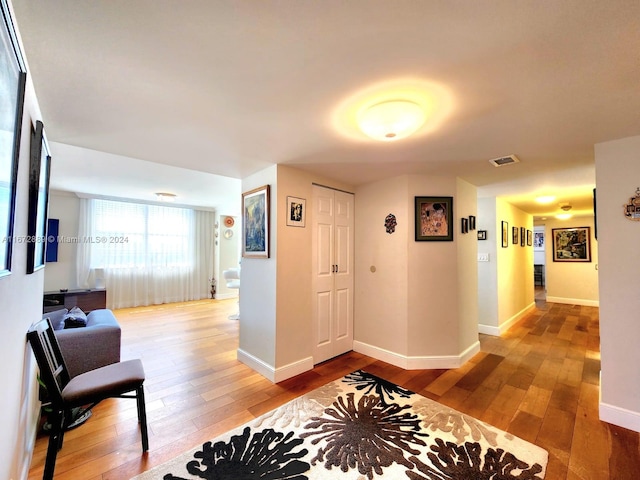 hallway with hardwood / wood-style flooring