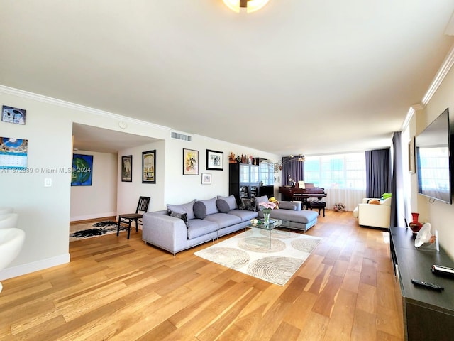 living room featuring crown molding and light hardwood / wood-style floors