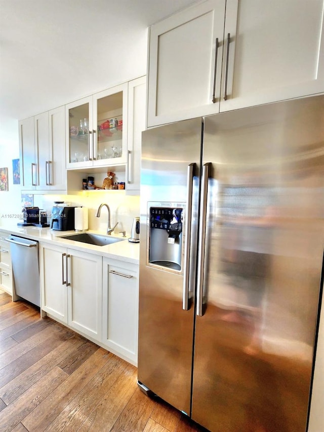 kitchen featuring appliances with stainless steel finishes, sink, and white cabinetry