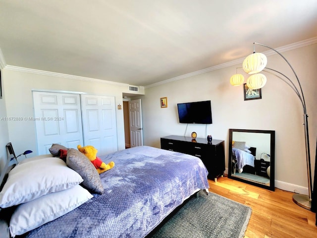 bedroom featuring light hardwood / wood-style flooring, a closet, and crown molding