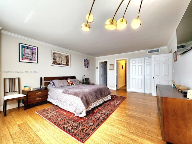 bedroom with hardwood / wood-style flooring, ornamental molding, and an AC wall unit