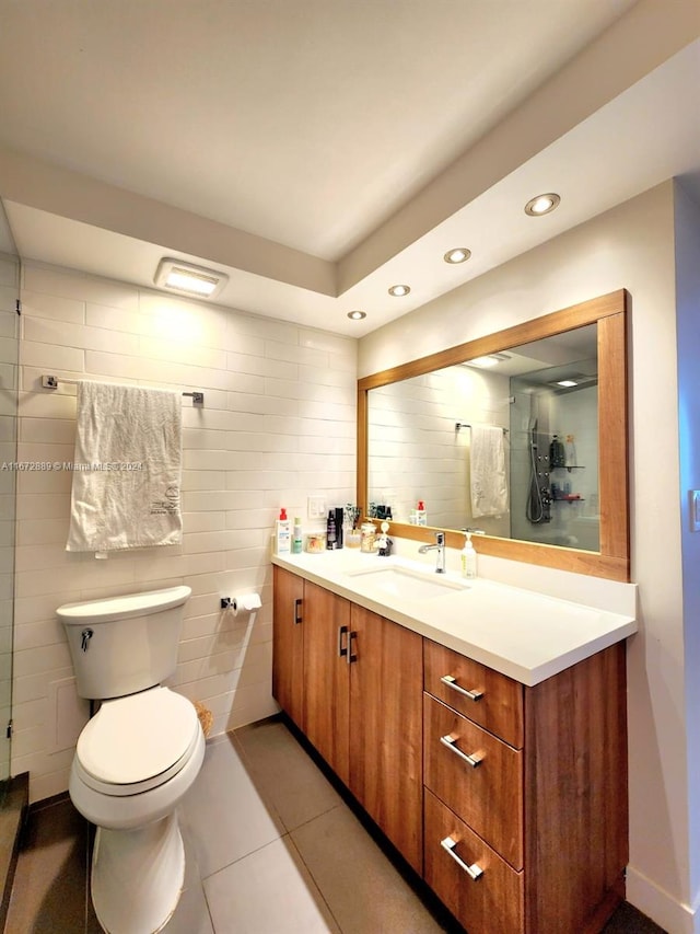 bathroom featuring tile walls, vanity, toilet, and tile patterned floors