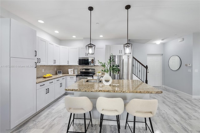 4184 Cascada Cir, Cooper City, FL 33024 - kitchen featuring white cabinetry, a kitchen island with sink, appliances with stainless steel finishes, and decorative light fixtures