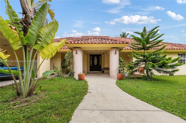 doorway to property with a lawn