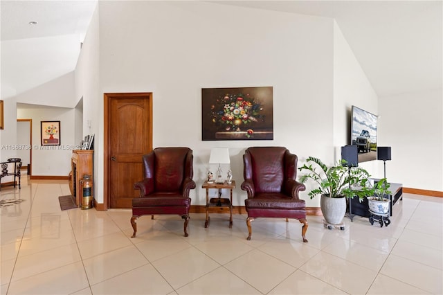 sitting room with light tile patterned flooring and high vaulted ceiling