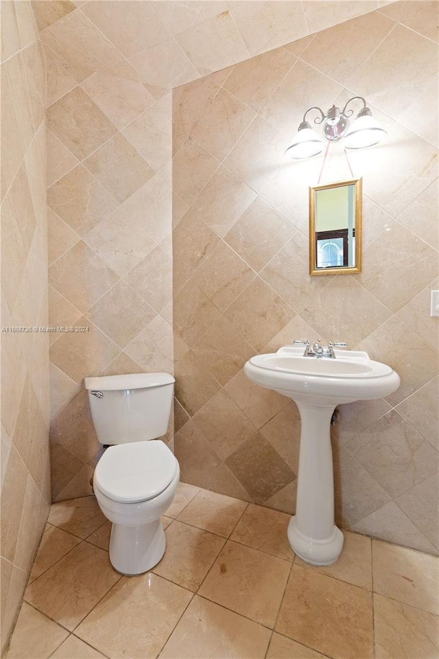 bathroom with tile walls and toilet