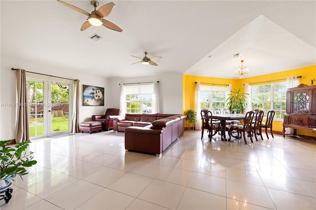 tiled living room featuring ceiling fan with notable chandelier and lofted ceiling