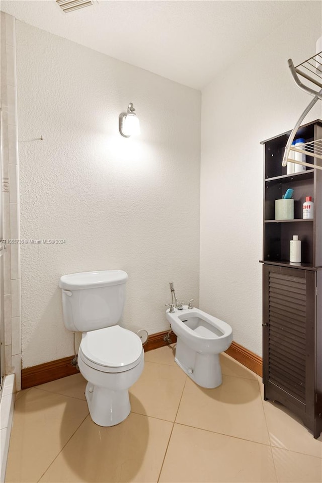 bathroom with walk in shower, tile patterned flooring, toilet, and a bidet