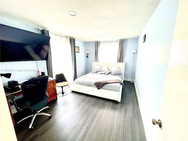 bedroom with a textured ceiling and dark wood-type flooring