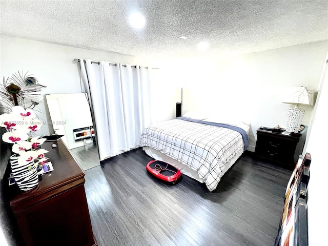 bedroom featuring a textured ceiling and dark hardwood / wood-style floors