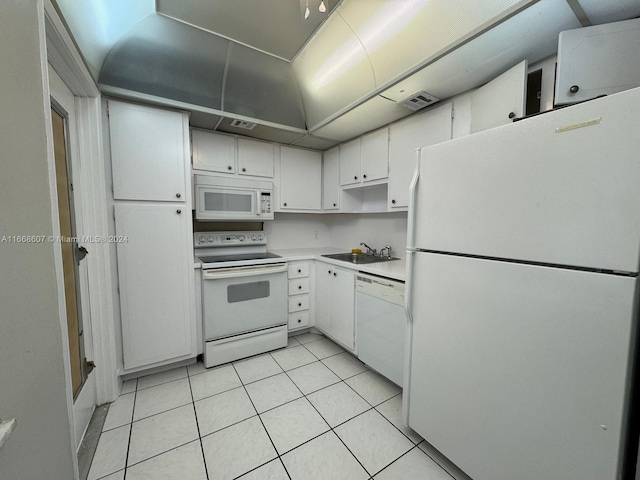 kitchen featuring white cabinets, sink, light tile patterned floors, and white appliances