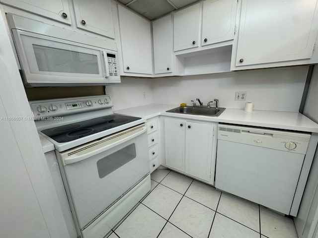 kitchen featuring light tile patterned flooring, white appliances, sink, and white cabinetry