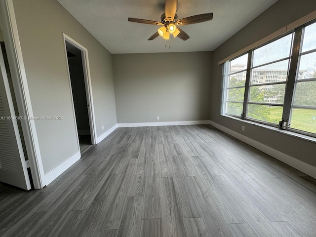 unfurnished room featuring dark hardwood / wood-style floors, a textured ceiling, and ceiling fan