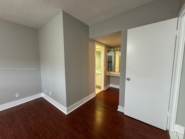 unfurnished room featuring dark hardwood / wood-style floors and a textured ceiling