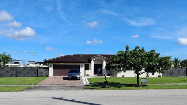 single story home with a garage and a front lawn