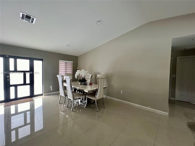 tiled dining room with lofted ceiling