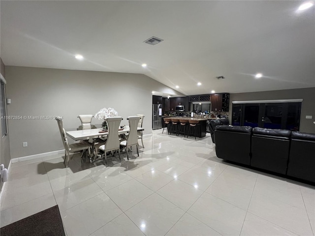 tiled dining space featuring lofted ceiling