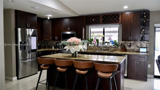 20461 SW 320th St, Homestead, FL 33030 - kitchen with appliances with stainless steel finishes, light tile patterned flooring, tasteful backsplash, light stone counters, and recessed lighting