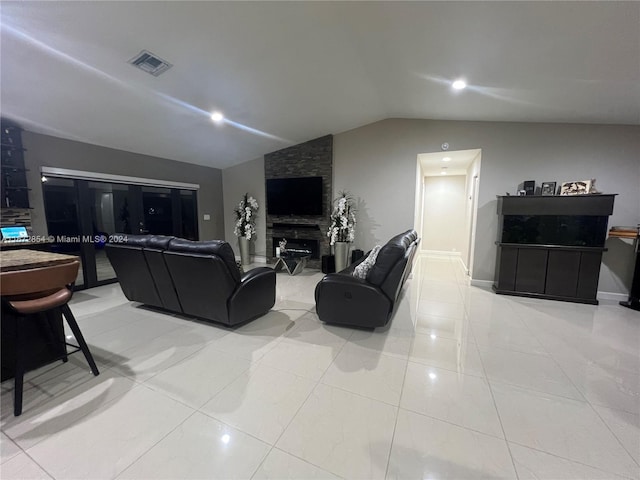 tiled living room with lofted ceiling and a large fireplace