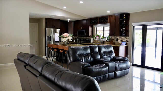 living room with light tile patterned flooring and vaulted ceiling