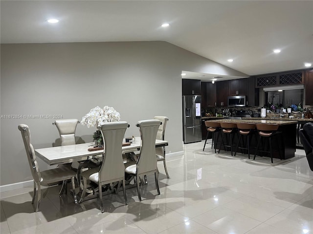 dining space with lofted ceiling and light tile patterned floors