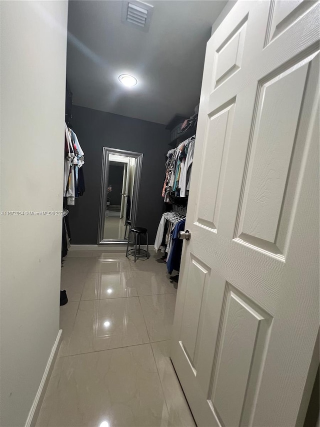 spacious closet with light tile patterned floors