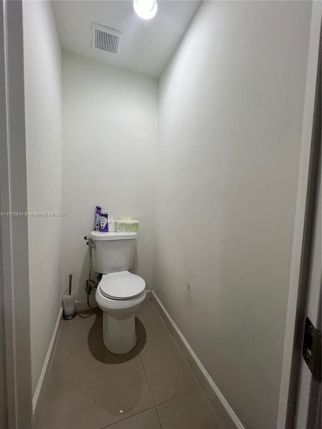 bathroom featuring toilet and tile patterned flooring