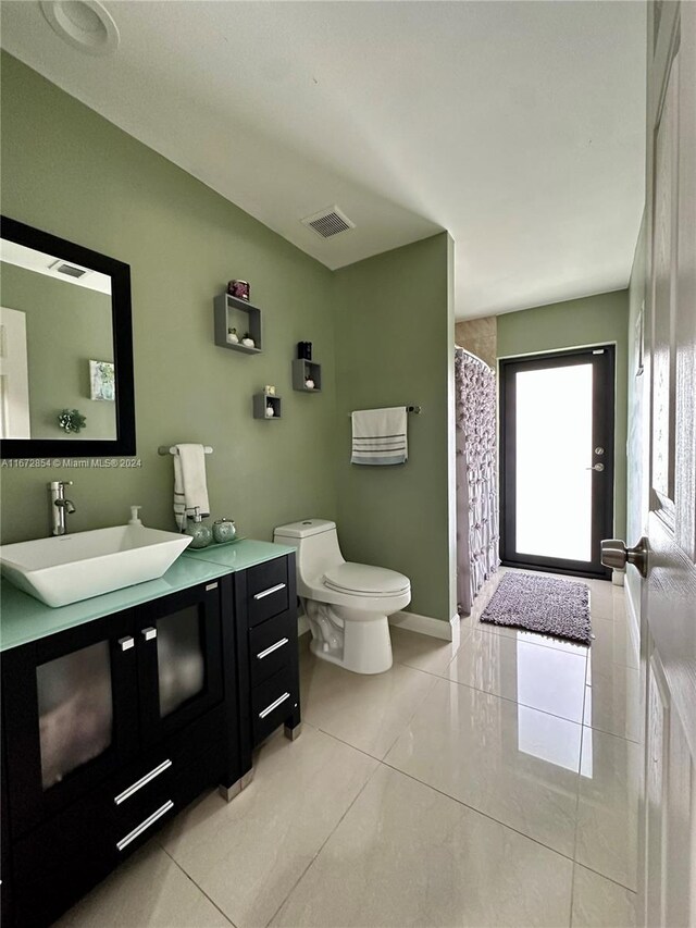 bathroom featuring vanity, toilet, tile patterned flooring, and a shower with shower curtain