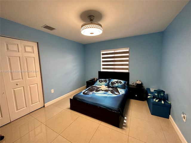 bedroom with a closet and light tile patterned floors