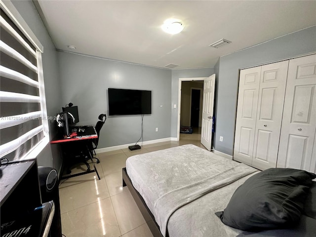 bedroom with a closet and light tile patterned floors