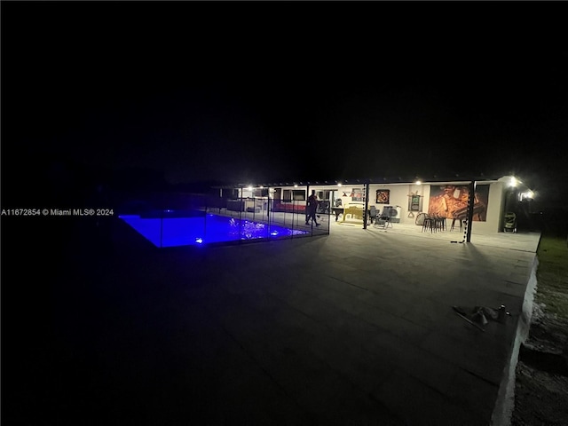 pool at twilight featuring a patio area