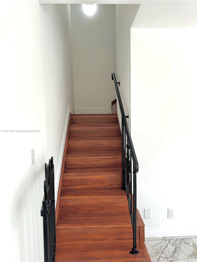 stairs featuring hardwood / wood-style floors