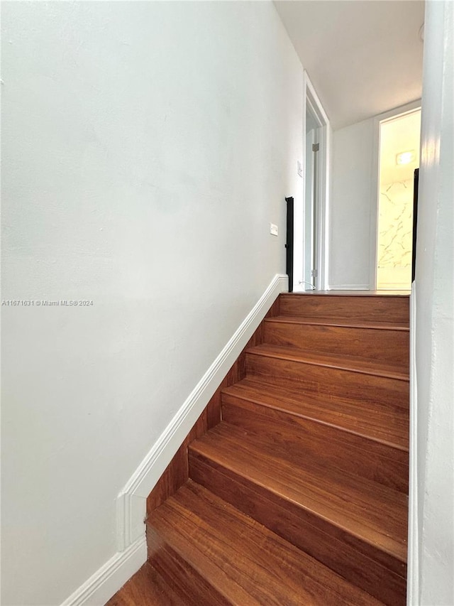 staircase with hardwood / wood-style flooring