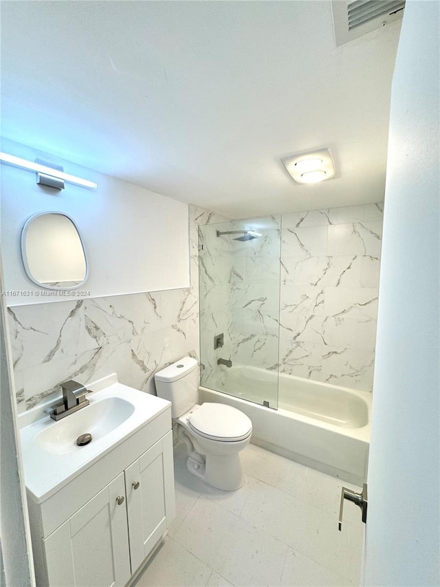 full bathroom featuring tile walls, vanity, toilet, and tiled shower / bath