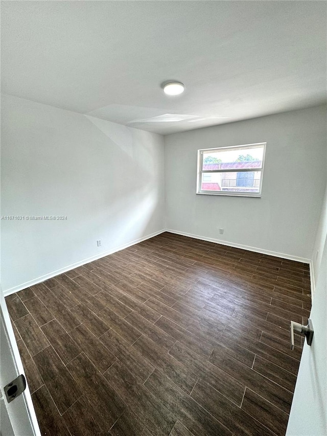 empty room with dark hardwood / wood-style flooring