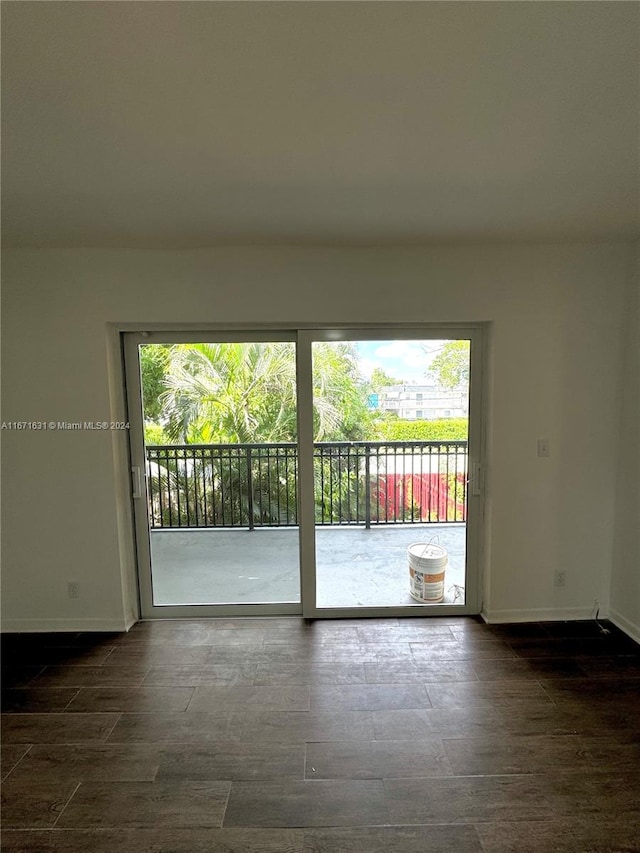 spare room featuring dark wood-type flooring and a wealth of natural light